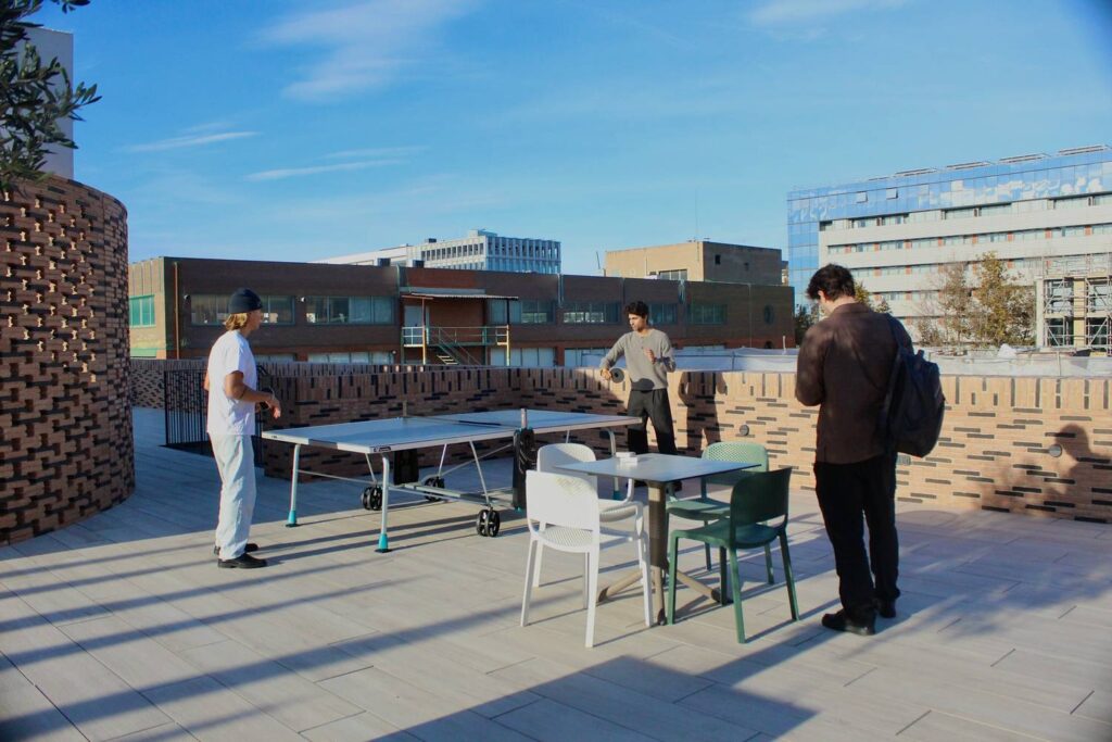 People working and socialising on a coworking and coliving terrace in Barcelona.